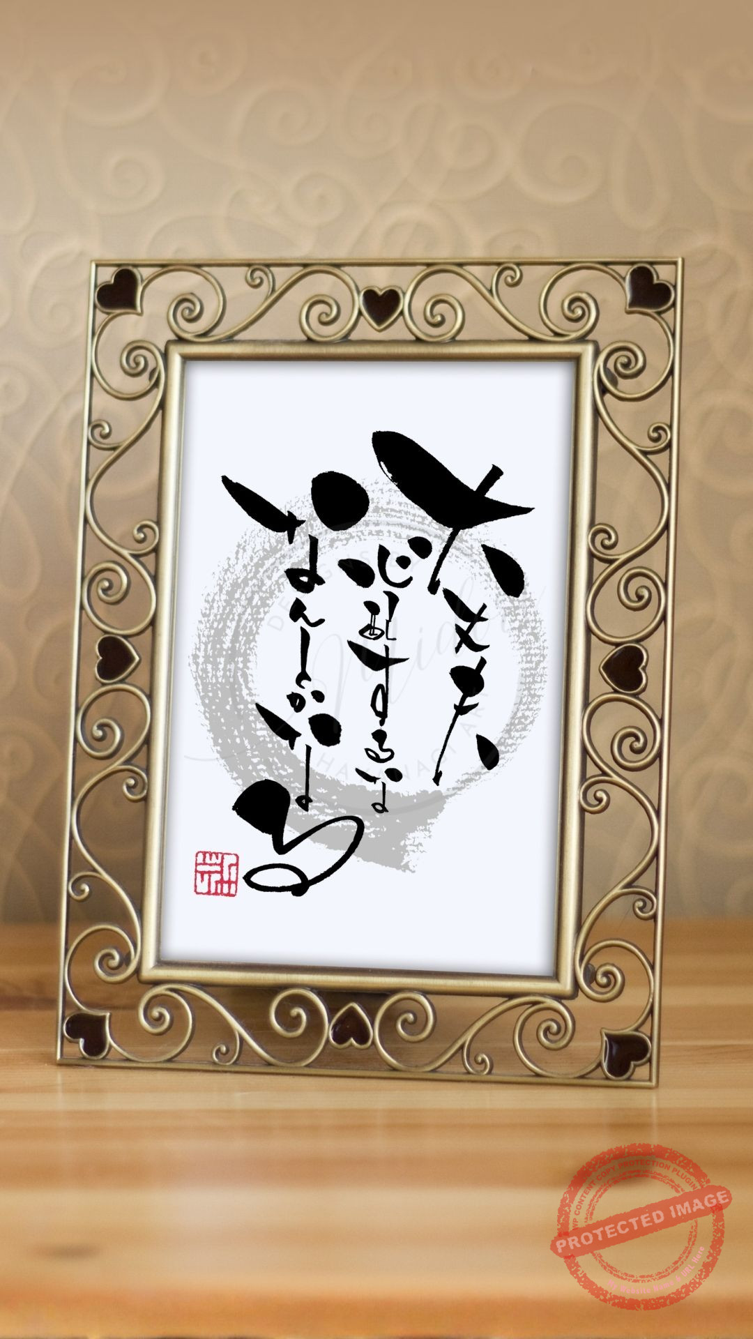 アンティーク調のゴールドのフォトフレームに収められた、縦書きの作品。中央背景には薄い墨色の円（円相）が描かれ、その上に重なるようにして『大丈夫、心配するな、なんとかなる』という言葉の筆文字。躍動感のある力強い筆致で三行にわたって書かれ、左下には「みどり」の赤い落款（印）が押されています。