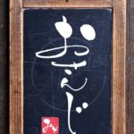 おやつの別名『おさんじ』を筆文字で書いたアート作品